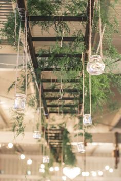 hanging mason jars filled with greenery are suspended from the ceiling