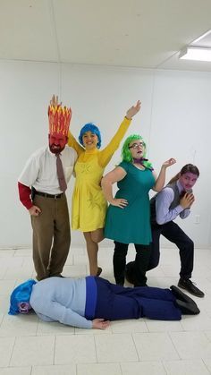 four people dressed in costume posing for a photo with one person laying on the ground