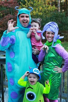 a family dressed up as monsters posing for a photo on the deck in halloween costumes