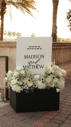 a sign that says madison and matthew on it with flowers in the center