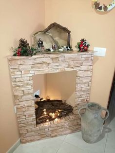 a fire place in the corner of a room with candles on it and a mirror above it