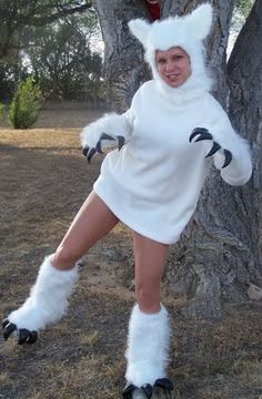 a woman dressed as a cat standing in front of a tree with her legs spread out