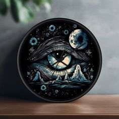 a clock with an all seeing eye on it's face and mountains in the background