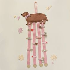 a pink and white striped wall hanging with a brown dog on it's side