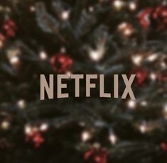 the word netflix spelled out in front of a christmas tree with red and white lights