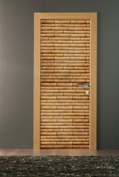 a wooden door with bamboo slats on the front and side panels, in an empty room