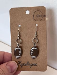 a pair of earrings with a football on it