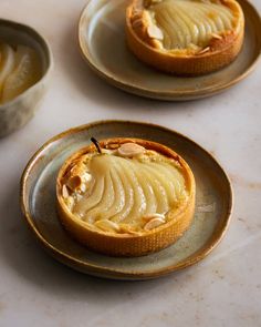 three small desserts are sitting on two plates