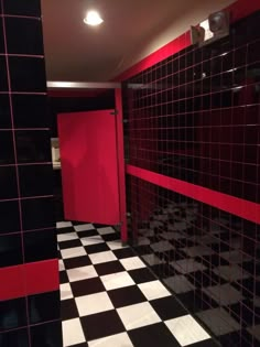 a black and white checkered floor in a bathroom with red accents on the walls