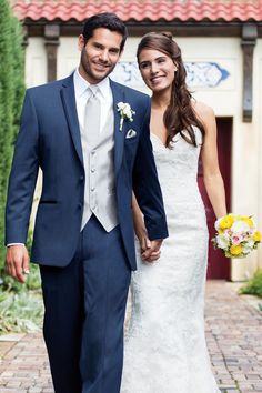 a bride and groom are holding hands