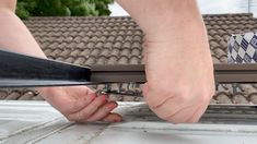 a person is cutting something with scissors on top of a roof