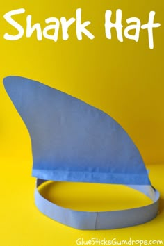 a shark hat made out of paper on a yellow background with the words shark hat above it