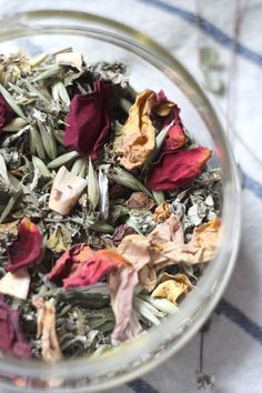 a glass bowl filled with dried flowers on top of a table