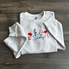 Step into a world of natural elegance with our latest Wildflower Sweatshirt Collection - where comfort meets botanical beauty in every stitch! Crafted from soft, high-quality materials, our sweatshirts are as cozy as they are chic.  Whether you're an avid nature lover, a free spirit at heart, or simply someone who appreciates the beauty of the great outdoors, our Wildflower Sweatshirt Collection invites you to bring a touch of the wild into your everyday wardrobe. Pair them with your favorite je Spring Long Sleeve Tops With Embroidered Logo, Long Sleeve Tops With Embroidered Logo For Spring, Embroidered Long Sleeve Sweatshirt For Spring, Spring Sweatshirt With Letter Embroidery And Long Sleeves, Spring Long Sleeve Sweatshirt With Letter Embroidery, Long Sleeve Sweatshirt With Letter Embroidery For Spring, Spring Cotton Sweatshirt With Floral Embroidery, Spring Casual Sweatshirt With Embroidered Graphics, Spring Floral Embroidered Crew Neck Sweatshirt