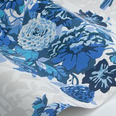 a blue and white flowered wallpaper with flowers on the side, in front of a white background