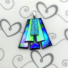 an image of two pendants made out of glass on a white background with hearts