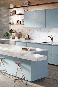 a kitchen with blue cabinets and marble counter tops, two stools at the island