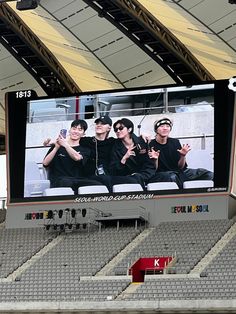 a group of men sitting on top of a stadium bleachers