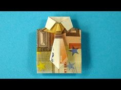 an origami model of a building made out of money on a blue background