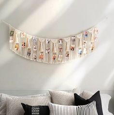 a white couch sitting next to a wall with pictures hanging from it's sides