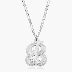 Our popular Double Plated Iced Out Initial Necklace boasts a chic and elegant design, handcrafted to perfection. The model showcases the necklace with an 18-inch Figaro chain (see video for reference). You can personalize this item with Letters, Numbers, and Roman Numerals and choose from chain lengths of 14", 16", 18", and 20". Each chain features a lobster clasp closure for secure wear.Chain width:Cuban Chain - 3.7 mmFigaro Chain - 3 mm Classic Polished Initial Pendant Jewelry, Luxury Personalized Silver Initial Necklace, Luxury Figaro Chain Necklace With Pendant, Luxury Figaro Chain Pendant Jewelry, Luxury Figaro Chain Pendant Necklace, Yellow Gold Initial Pendant With Figaro Chain, White Gold Polished Initial Pendant Jewelry, Personalized Silver Round Chain Necklace, Silver Round Initial Necklace For Formal Occasions