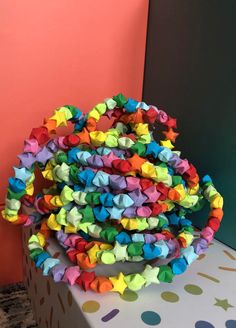 a stack of multicolored origami stars sitting on top of a gift box