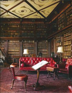 an old library with red leather couches and bookshelves filled with lots of books