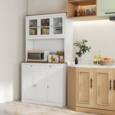 a kitchen with white cabinets and wood flooring next to a wall mounted microwave oven