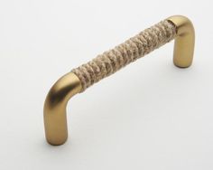 a close up of a metal handle on a white surface with a rope wrapped around it