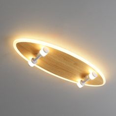 two lights that are on the ceiling above a skateboard in a room with white walls