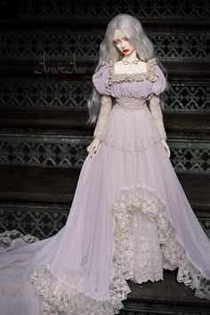 a doll is dressed in a white gown and veil on the stairs with long hair