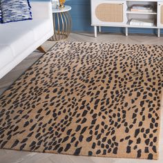 a leopard print rug on the floor in a room with blue walls and white furniture