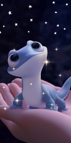 a close up of a person's hand holding a small toy dinosaur with stars in the background