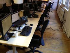 an office with multiple computers on the desk