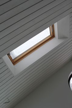 the skylight is shining brightly into the room with white walls and wood slats