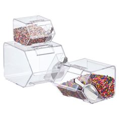 two clear containers filled with sprinkles on top of each other next to a container