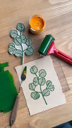 a table with some crafting supplies on it and a green leaf stencil