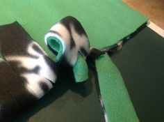 a roll of tape is laying on top of a piece of green material with black and white stripes