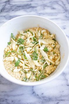 a white bowl filled with food on top of a marble counter