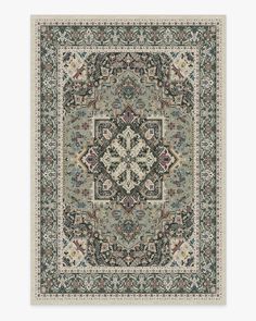 a rug with an ornate design on the front and back side, in grey tones