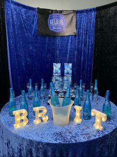 a blue table topped with lots of bottles and lights next to a sign that says brit