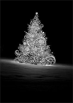 a lit up christmas tree sitting in the middle of a snow covered field at night