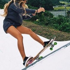 a woman riding a skateboard down the side of a ramp