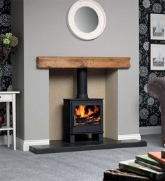 a living room with a wood burning stove in it's center and a mirror on the wall