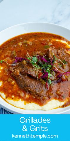 a white bowl filled with meat and grits on top of a blue table cloth