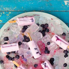 popsicles and blueberries are on top of ice