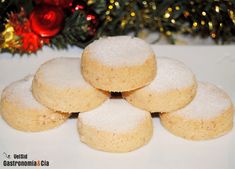 some sugar cookies are stacked on top of each other in front of a christmas tree