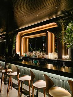 the bar is lined with wooden chairs and plants