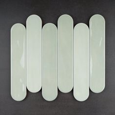 five white plates lined up in a row on a black surface with no one sitting at the top