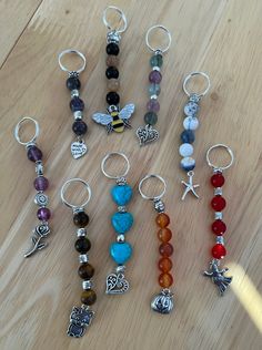 several different types of beads and charms on a wooden table with a keychain